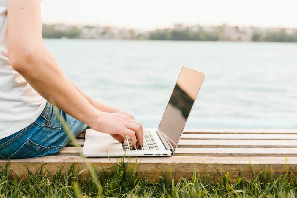 sideview-man-using-laptop-by-water